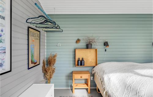 Awesome Home In Mesinge With Wifi في Mesinge: غرفة نوم بحائط ازرق مع سرير وطاولة
