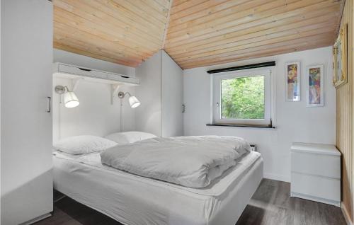 エーベルトフトにあるAmazing Home In Ebeltoft With Kitchenの木製の天井のベッドルーム1室(白いベッド1台付)