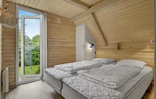 エーベルトフトにあるAmazing Home In Ebeltoft With 4 Bedrooms And Saunaの窓付きの客室の大型ベッド1台分です。