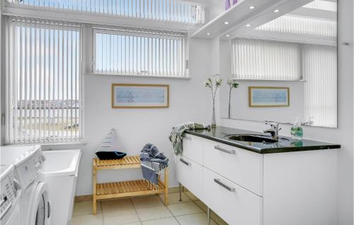 a white kitchen with a sink and a washing machine at Awesome Home In Assens With House Sea View in Assens
