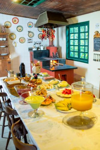 un lungo tavolo con piatti di cibo e bevande di Hotel Fazenda Pirapetinga a Piranga
