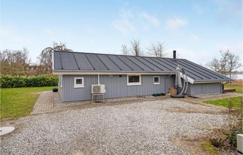 a gray house with a gravel driveway at Lovely Home In Kerteminde With Wifi in Kerteminde