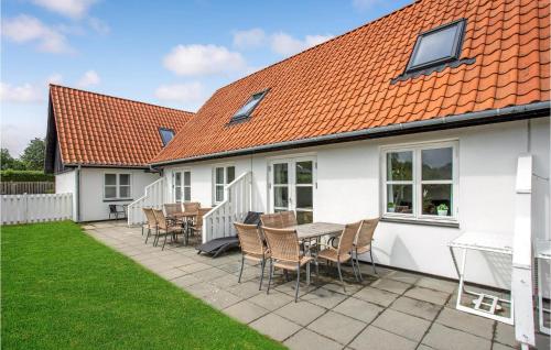 a white house with a table and chairs at 2 Bedroom Nice Apartment In Allinge in Allinge