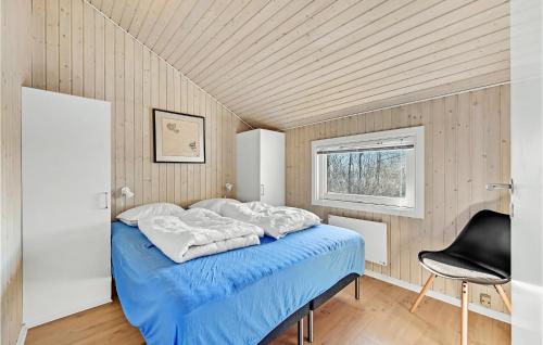 Lovely Home In Kerteminde With Wifi في كيرتيمايند: غرفة نوم بسرير ازرق وكرسي