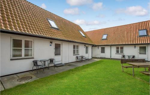 a patio with chairs and a table in a yard at 2 Bedroom Nice Apartment In Allinge in Allinge