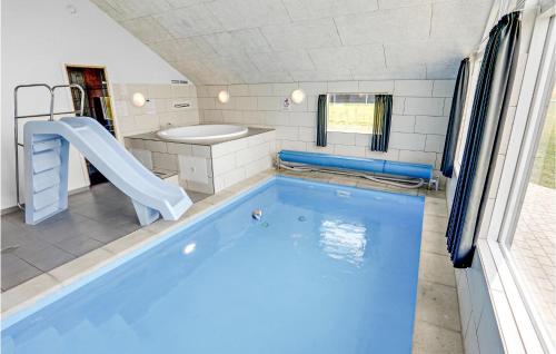 a swimming pool with a slide in a bathroom at Gorgeous Home In Bogense With Indoor Swimming Pool in Bogense