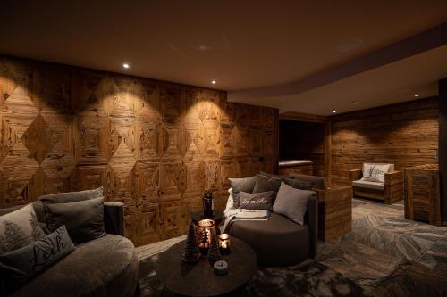 a room with a wooden wall with a couch and a table at The Falcon in Lech am Arlberg
