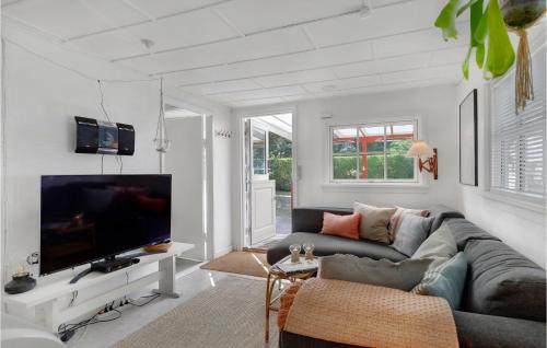 a living room with a couch and a flat screen tv at Holiday Home Midtvej Nexø V in Neksø