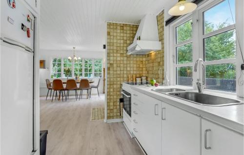 eine Küche mit weißen Schränken und ein Esszimmer in der Unterkunft 2 Bedroom Cozy Home In Væggerløse in Bøtø By