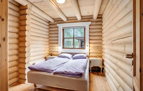 a small bedroom with a bed in a wooden room at 3 Bedroom Amazing Home In Fars in Hvalpsund
