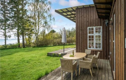 a wooden deck with a table and chairs on it at Two-Bedroom Holiday Home In Faxe in Faxe