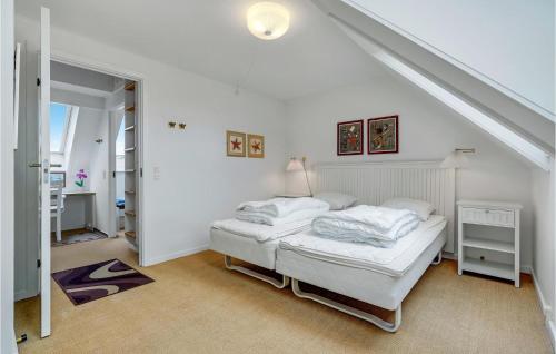 a white bedroom with a bed and a staircase at Cozy Apartment In Borre With House Sea View in Borre