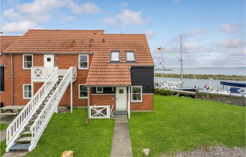 a red brick house with a white door and a dock at Apartment Klintholm Havneby Borre Iii in Borre
