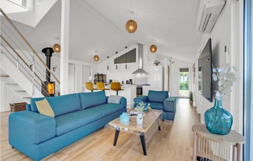 a living room with a blue couch and a table at Holiday Home Brombærvej Skjern Xii in Lem