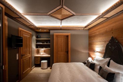 a bedroom with a bed and a television in it at The Falcon in Lech am Arlberg