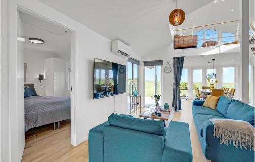 4 Bedroom Stunning Home In Skjern في Lem: غرفة معيشة مع أريكة زرقاء وغرفة نوم