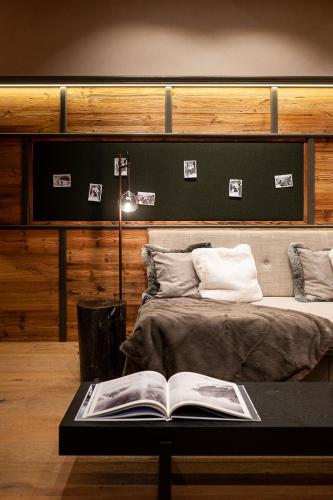 a bedroom with a bed with a book on a table at The Falcon in Lech am Arlberg
