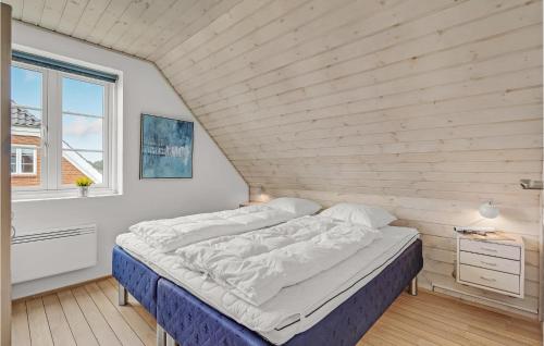 Ce lit se trouve dans une chambre dotée d'un mur en bois. dans l'établissement Beautiful Home In Rm With Wifi, à Havneby