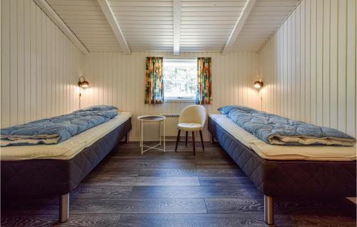 ホにある3 Bedroom Awesome Home In Blvandのベッド2台、テーブル、椅子が備わる客室です。