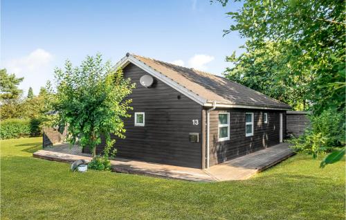 a small black house with a wooden deck at Holiday Home Pengeurtvej Vordingborg V in Vordingborg