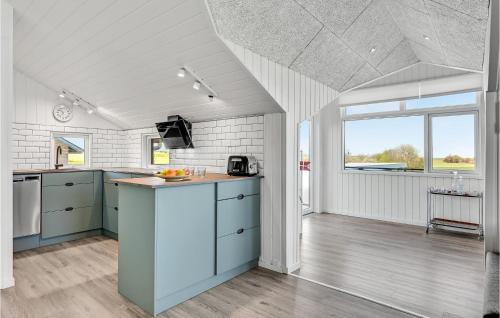 a kitchen with blue cabinets and a large window at Two-Bedroom Holiday Home In Lemvig in Lemvig