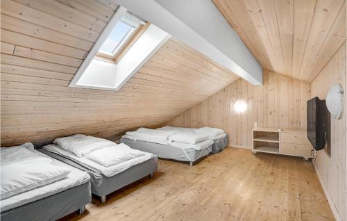 a attic room with two beds and a skylight at Gorgeous Home In Idestrup With Sauna in Marielyst