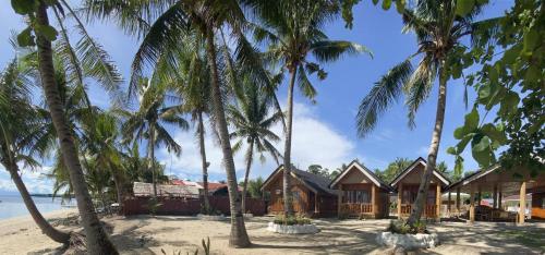 a resort on the beach with palm trees at Hola Beach Resort in Siquijor