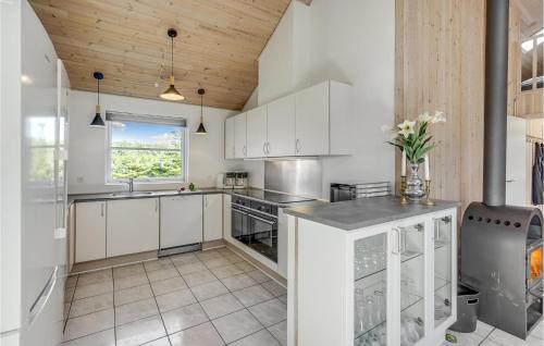a kitchen with white cabinets and a window at Gorgeous Home In Idestrup With Sauna in Marielyst