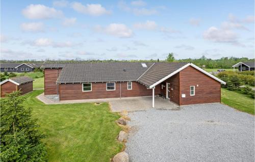 a large wooden house with a large backyard at Gorgeous Home In Idestrup With Sauna in Marielyst