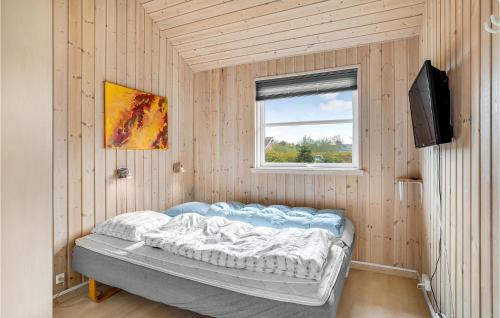 a small room with a bed and a television at Gorgeous Home In Idestrup With Sauna in Marielyst