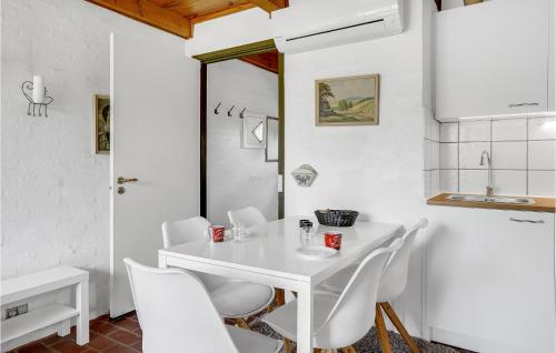 een witte eetkamer met een witte tafel en witte stoelen bij 2 Bedroom Nice Home In Rm in Rømø Kirkeby