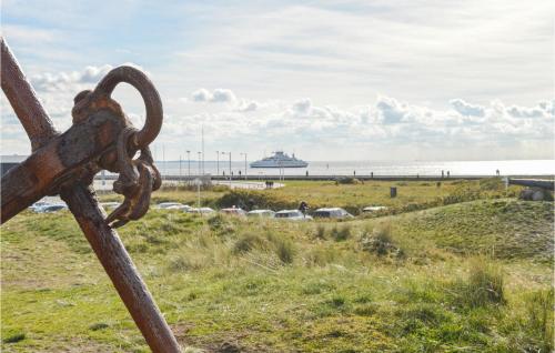 a rusty chain link fence with the ocean in the background at 2 Bedroom Lovely Home In Rømø in Rømø Kirkeby