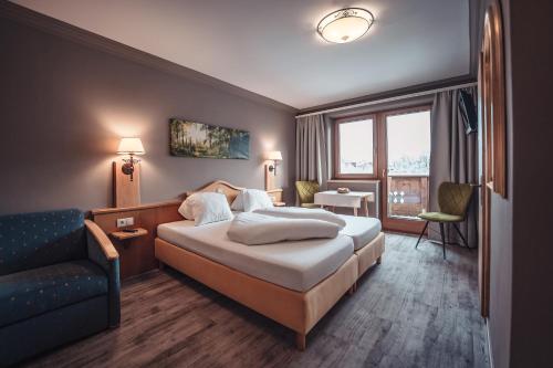 um quarto de hotel com uma cama e um sofá em Schwaiger em Breitenbach am Inn