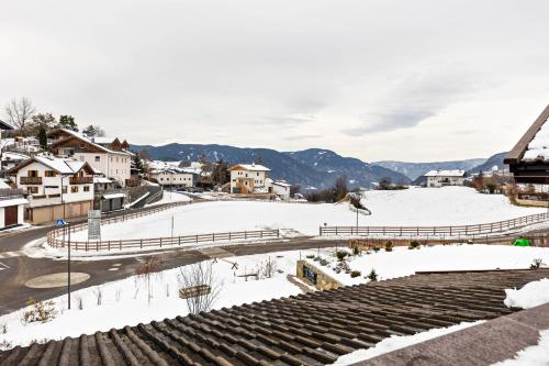 a view of a snow covered town with mountains at Florerhof Ferienwohnung Lavendel in Vols am Schlern