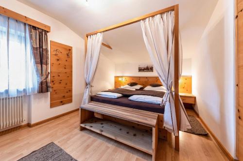 a bedroom with a bed with a mosquito net at Florerhof Ferienwohnung Lavendel in Vols am Schlern