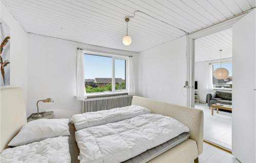 ThorsmindeにあるNice Home In Ulfborg With House A Panoramic Viewの白いベッドルーム(ベッド1台、窓付)