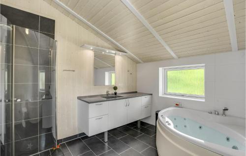 y baño con bañera, lavamanos y ducha. en Nice Home In Lgstr With Wifi, en Løgsted
