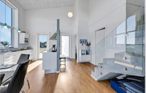 a kitchen and living room with white walls and a staircase at Holiday Home Ringkøbing 3 in Søndervig