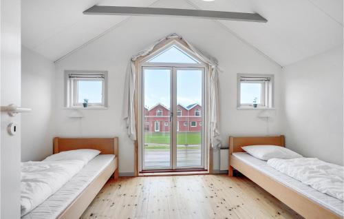 Duas camas num quarto com uma janela grande em Beautiful Apartment In Hadsund With House Sea View em Hadsund