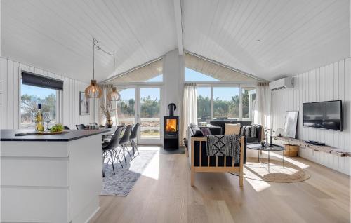 a kitchen and living room with a fireplace in a house at Holiday Home Hermodsvej Harboøre Xi in Harboør