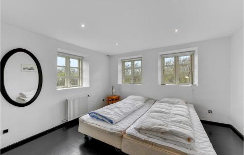 Fjand GårdeにあるAwesome Home In Ulfborg With 12 Bedrooms And Wifiの白いベッドルーム(ベッド1台、鏡付)