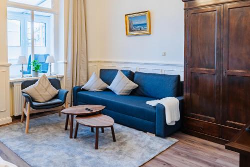 a living room with a blue couch and a table at Ferienwohnungen Am Kirchenplatz in Warnemünde