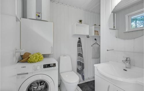 a white bathroom with a washing machine and a toilet at Amazing Home In Rm With 3 Bedrooms And Wifi in Bolilmark
