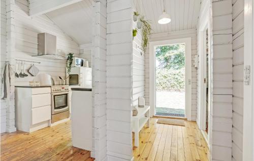 a kitchen with white walls and a wooden floor at Two-Bedroom Holiday Home In Krusa in Kruså