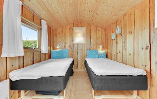 2 łóżka w niewielkim pokoju z drewnianymi ścianami w obiekcie 3 Bedroom Stunning Home In Aabenraa w mieście Aabenraa