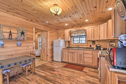 a kitchen with wooden cabinets and a white refrigerator at Quiet and Secluded Berea Cabin on 70-Acre Farm! in Berea