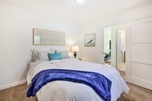 a white bedroom with a large bed and a mirror at Quiet Carpinteria Cottage By Town and Beaches in Carpinteria