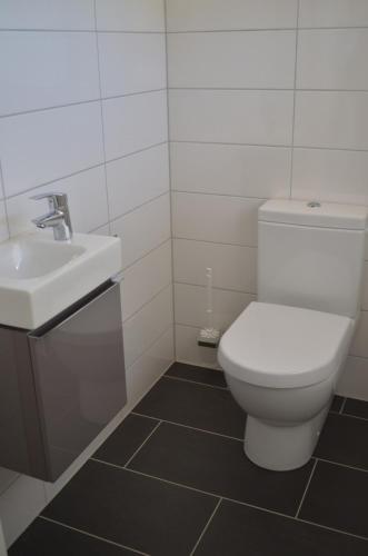 a bathroom with a white toilet and a sink at Ferienwohnung Fam Wernicke in Preußisch Oldendorf