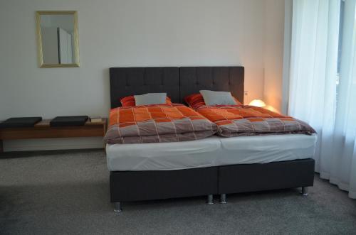 a bedroom with a bed with an orange comforter at Ferienwohnung Fam Wernicke in Preußisch Oldendorf