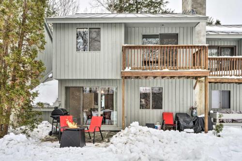 a house with a deck and red chairs in the snow at Hartford Escape with Fire Pit about 3 Mi to Ski and Golf! in Hartford